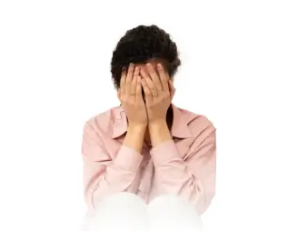 Person sitting with their face in their hands, expressing distress or frustration