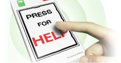 Hand pressing the 'Press for Help' button on a KISA personal alarm device, highlighting its emergency function