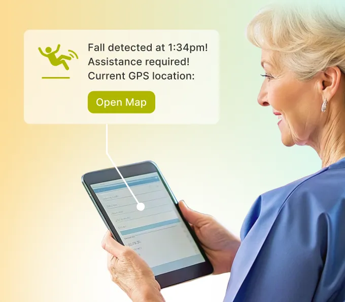 Senior woman using a tablet showing a notification that reads 'Fall detected at 1:34pm! Assistance required! Current GPS location: Open map button
