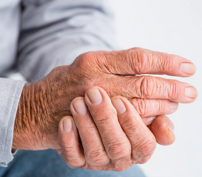 Close-up of senior hands demonstrating KISA arthritis-friendly devices with easy-to-press buttons for people with limited hand mobility