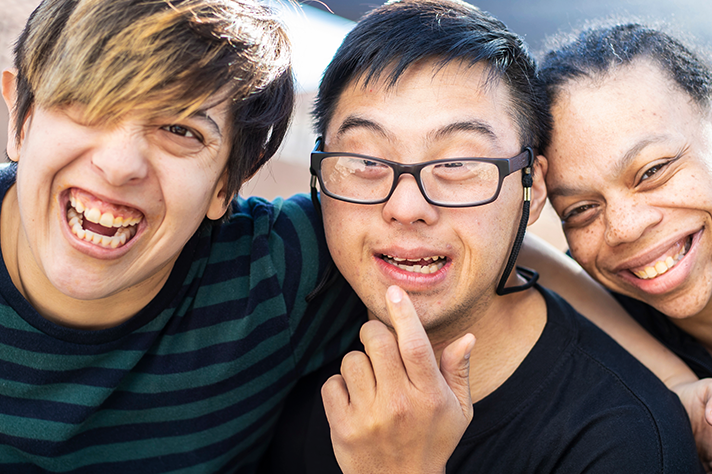 Happy children with autism smiling together, showing benefits of routine and independence support
